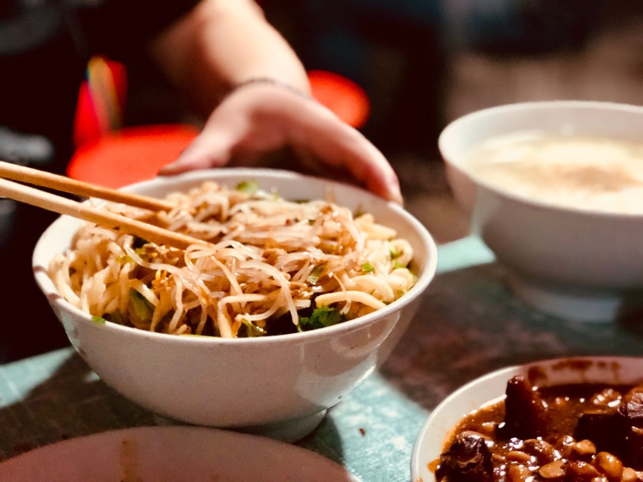 Close-up of a delicious Asian noodle bowl with bean sprouts and chopsticks, highlighting authentic cuisine.