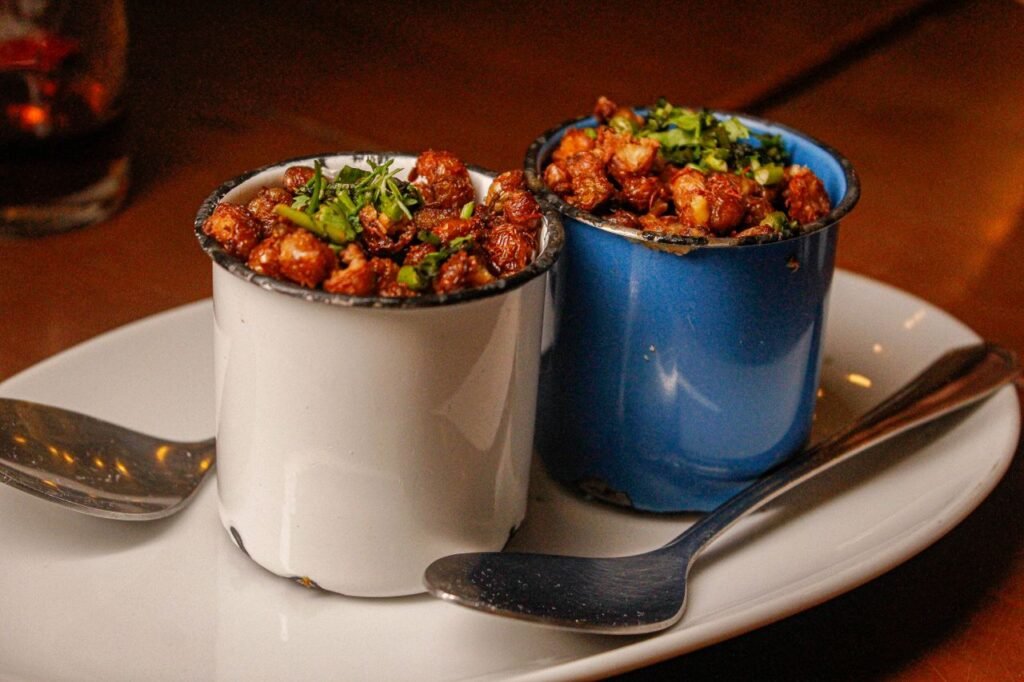 Delicious Brazilian snacks served in colorful cups on a plate, perfect for a culinary experience.