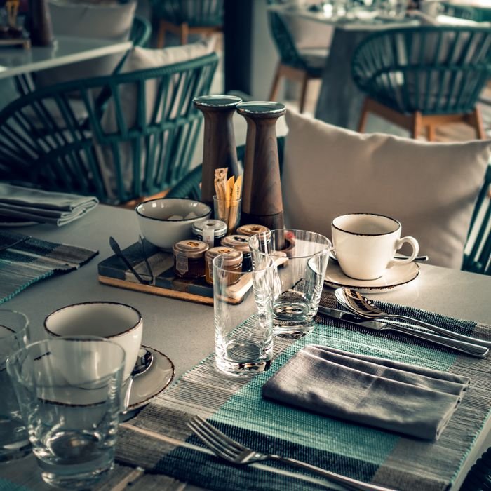 From above of restaurant table set with glassware and silverware before lunch time